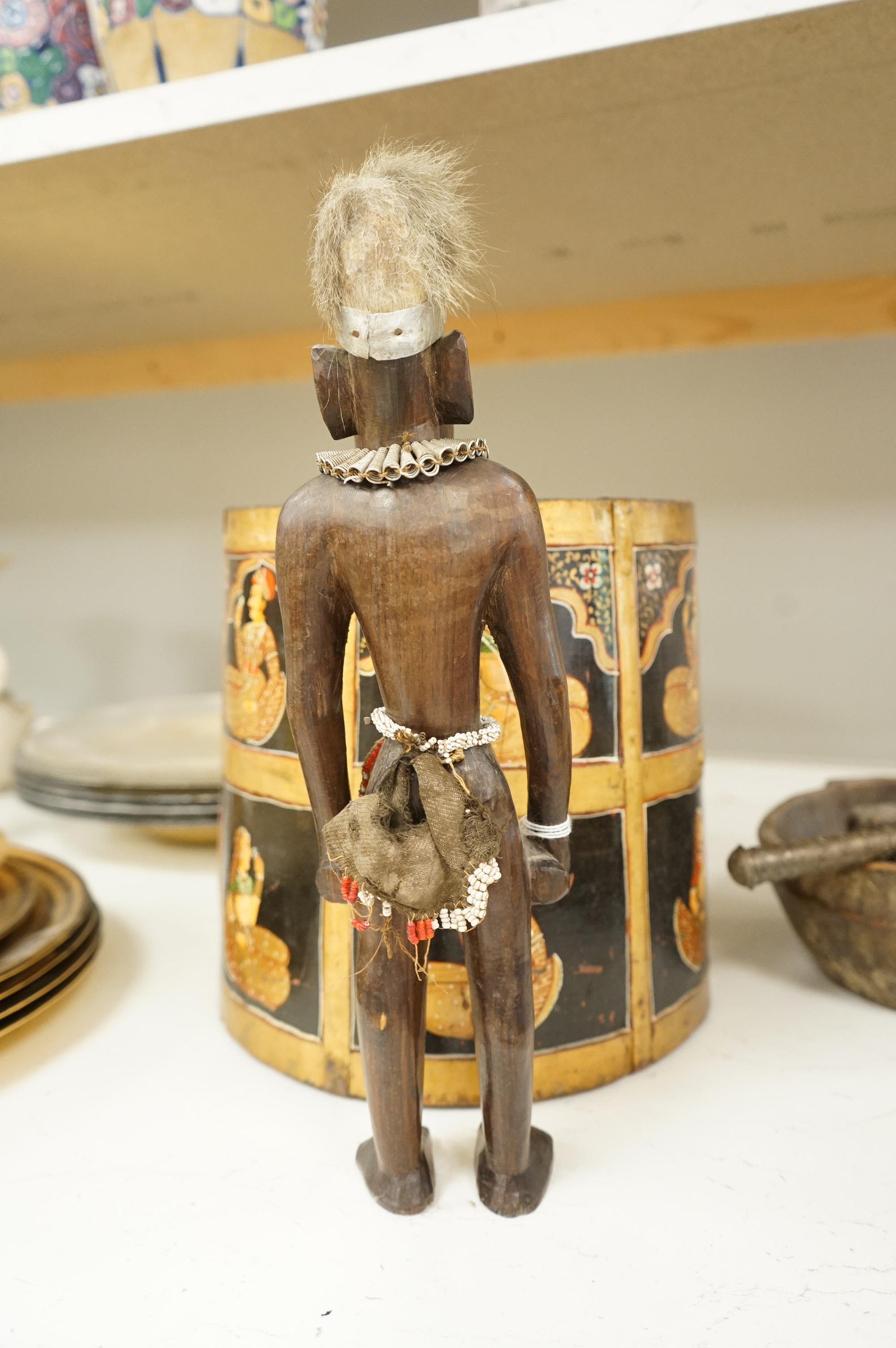 A collection of tribal and Asian collectables including a Tibetan prayer wheel, carvings, etc.